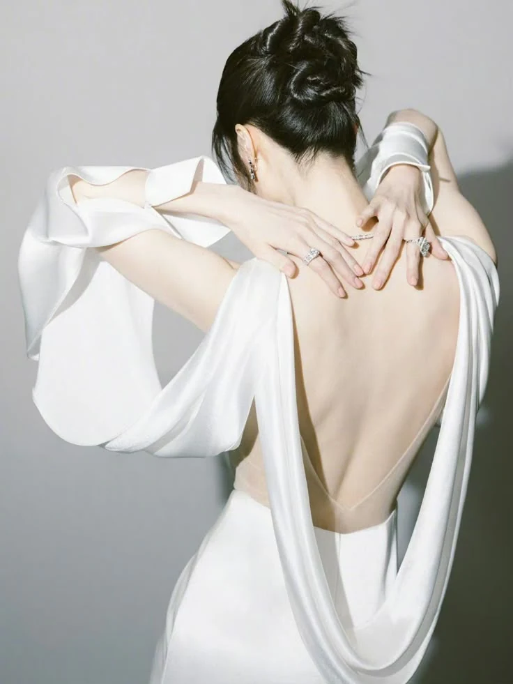 Silhouette studies editorial image of a woman in a sculptural white dress seen from the back